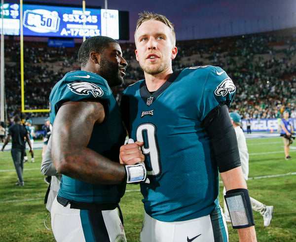 Defensive end Vinny Curry talks with Nick Foles after the victory in Los Angeles. Courtesy Yong Kim / Staff Photographer