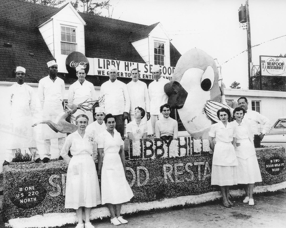 Libby Hill Seafood parade float and staff, circa 1957. Included are Barbara King (Walker), Frank Simpson, Joyce Kincaid (Inman), and owner Luke Conrad. Luke Conrad opened the first Libby Hill Seafood Restaurant in 1953. Courtesy the King Family