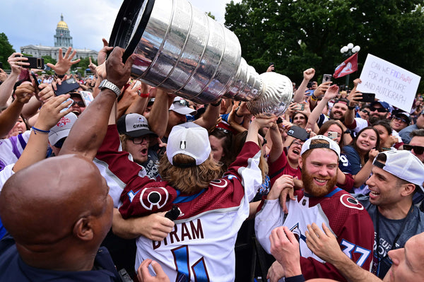 Colorado Avalanche Bowen Byram (4) and JT Compher (37) show Stanley Cup closer to fan at Civic Center Park in Denver on June 30, 2022. Hyoung Chang / The Denver Post