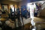 Chris Gutierrez, second from right, helps his grandmother, Edelmira Gutierrez, down the stairs of their flooded house and into a waiting fire department truck in the Concord Bridge neighborhood as Addicks Reservoir surpasses capacity due to near constant rain from Tropical Storm Harvey Tuesday, Aug. 29, 2017 in Houston. Courtesy Michael Ciaglo / Houston Chronicle