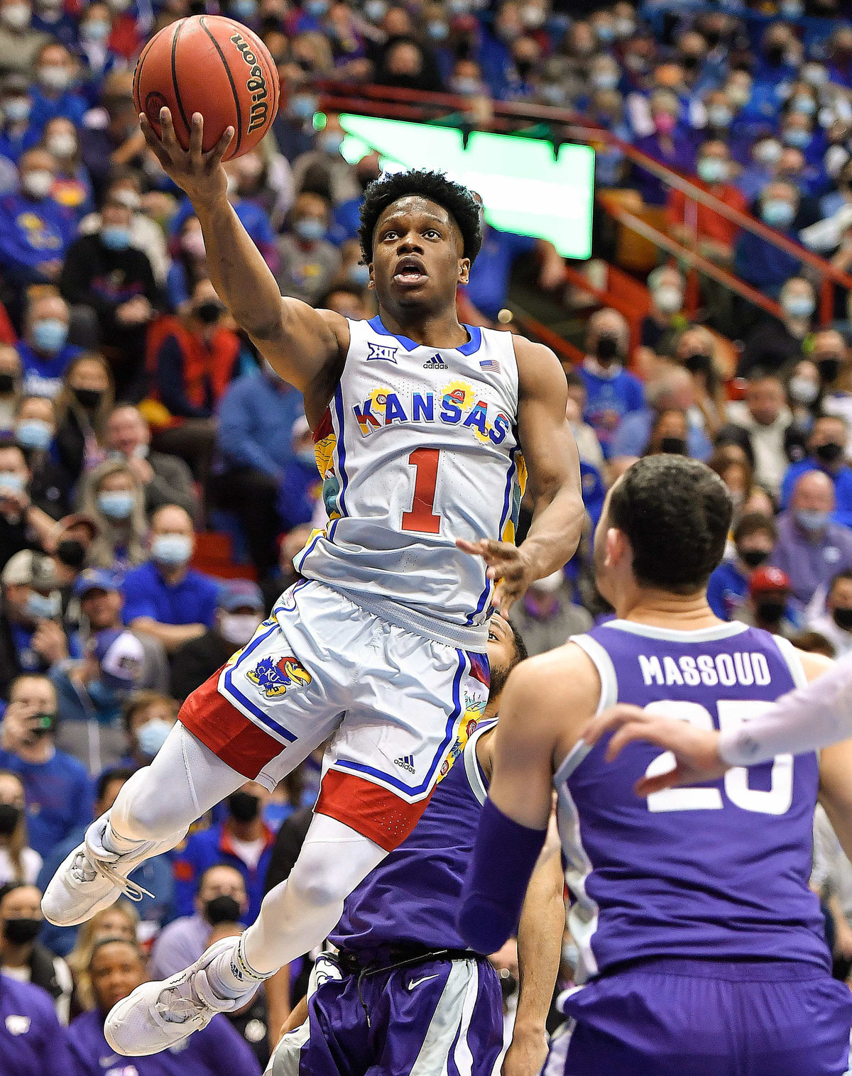 KU’s Joseph Yesufu sails past Kansas State’s Markquis Nowell, rear, and Ismael Massoud for a bucket. Rich Sugg / The Kansas City Star