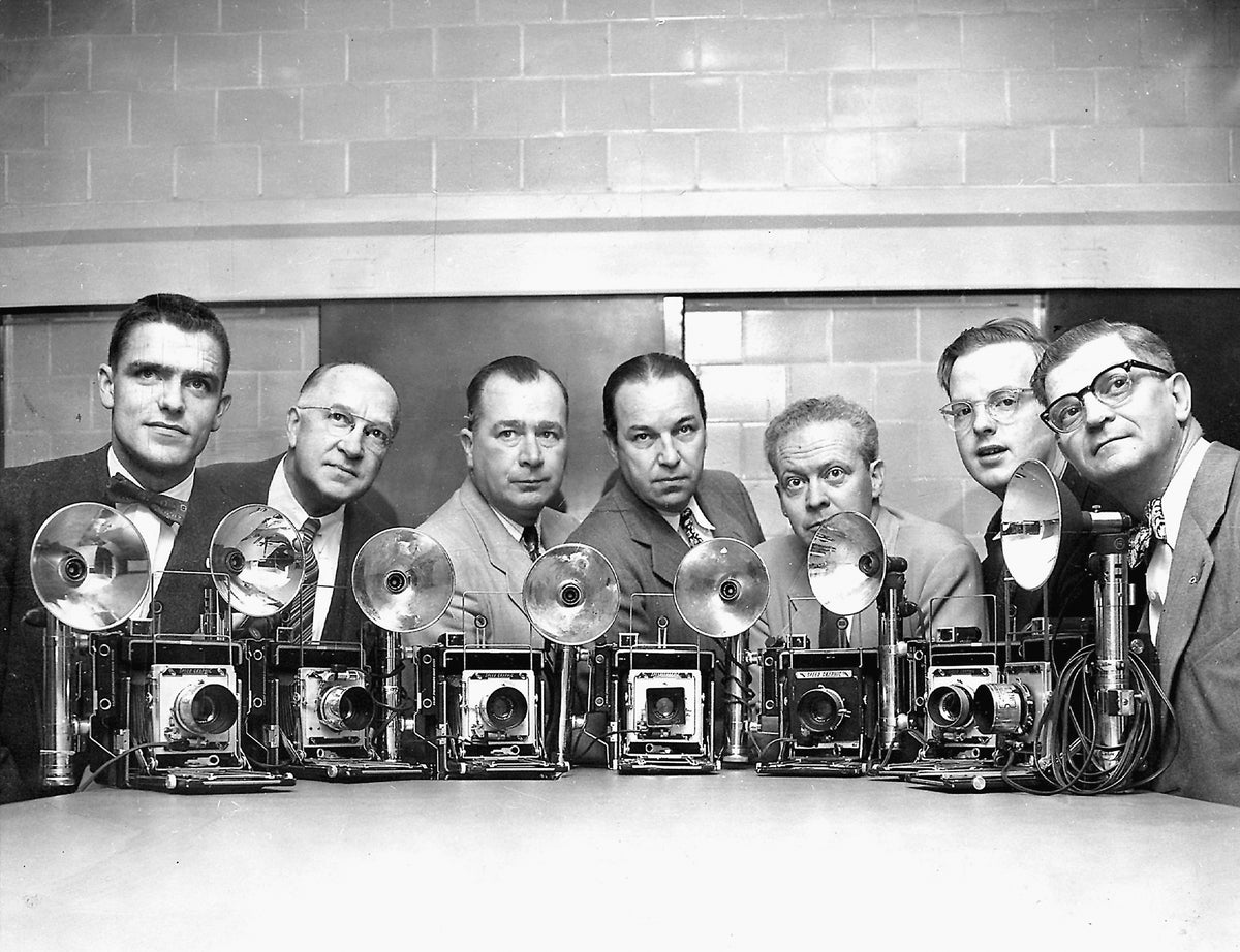 Providence Journal photographers who covered the chase and capture of escaped inmate DiFraia and won a Pulitzer Prize for the coverage, 1952. Pictured with their Speed Graphic cameras, from left: Robert F. McCrystal, Harry A. Scheer, John P. Callahan, chief photographer Clinton H. Cram, Frank J. Farley, Thomas D. Stevens, H. Raymond Ball. Courtesy The Providence Journal
