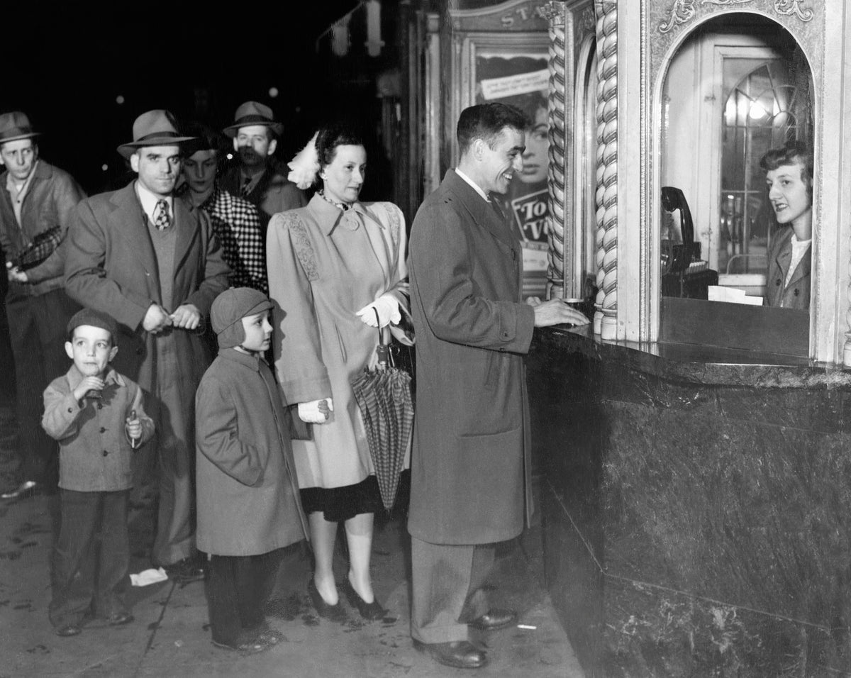 Ivan Small with his wife, Thelma Small, and their seven-year-old son, Ray Small, buying movie tickets at a theater on Main Street, 1948. Courtesy Jean (Small) Burns