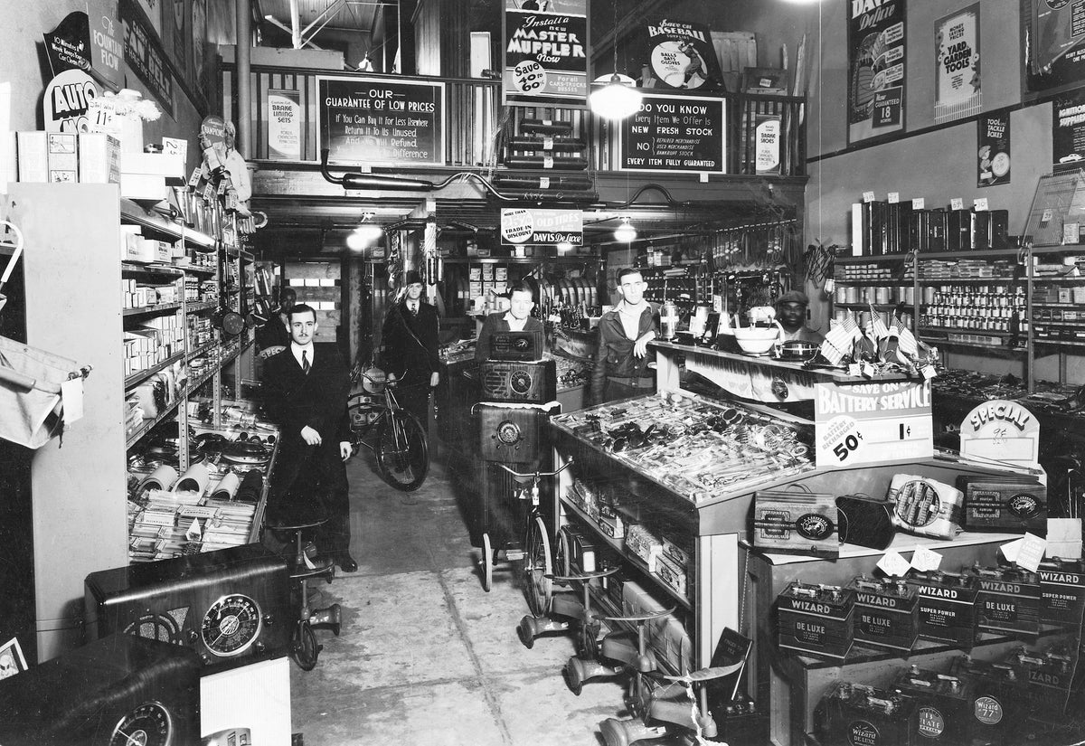Interior of R.L. "Bob" Carlos' Western Auto, located in the Pinehurst Hotel Building, circa 1936. Pictured from left are, R.L. "Bob" Carlos and five employees.