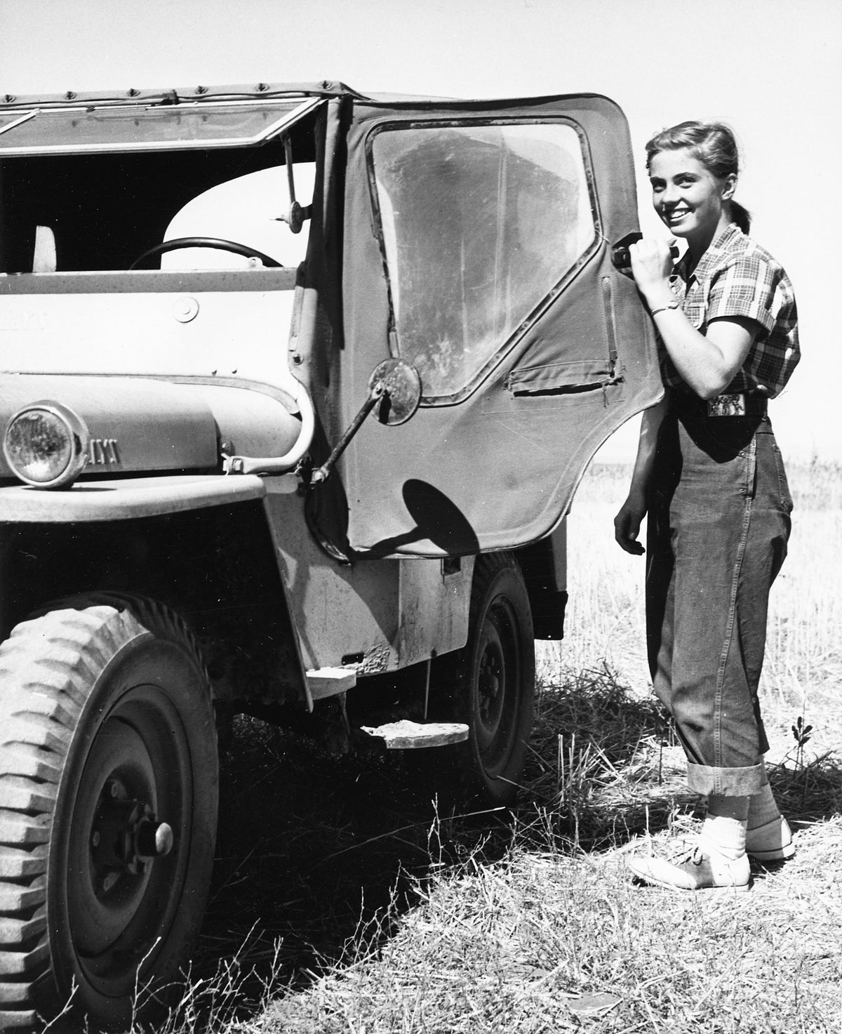 Cara McCann next to a jeep during the harvet at McCann's wheatfield, circa 1950s. Courtesy Nez Perce County Historical Society