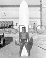 Lifeguard Dorian Paskowitz with surfboard at Belmont Park in Mission Beach, circa 1940. San Diego inaugurated lifeguard service in 1918 after thirteen people drowned on a single day in Ocean Beach. Initially lodged in the police department, lifeguards by 1935 numbered six full-time and thirteen part-time. During World War II, the city arranged for seven lifeguards to be exempted from the draft. The lifeguard service split off from the Police Department in 1947. CourtesySan Diego History Center (#79:650)
