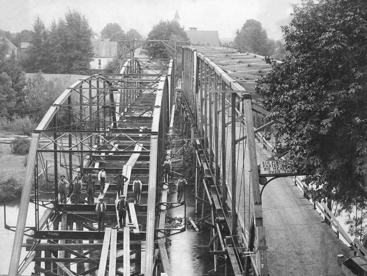 Workers constructing the second bridge on Washburn Street, circa 1909. The bridge on the right was demolished shortly after. Courtesy Linn County Historical Museum