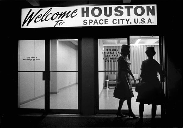 Flight attendants enter the international arrivals area at Hobby Airport in December 1967. Arrivals are greeted with a “Welcome to HOUSTON SPACE CITY, U.S.A.” sign over the door. Courtesy Richard Pipes/Houston Chronicle