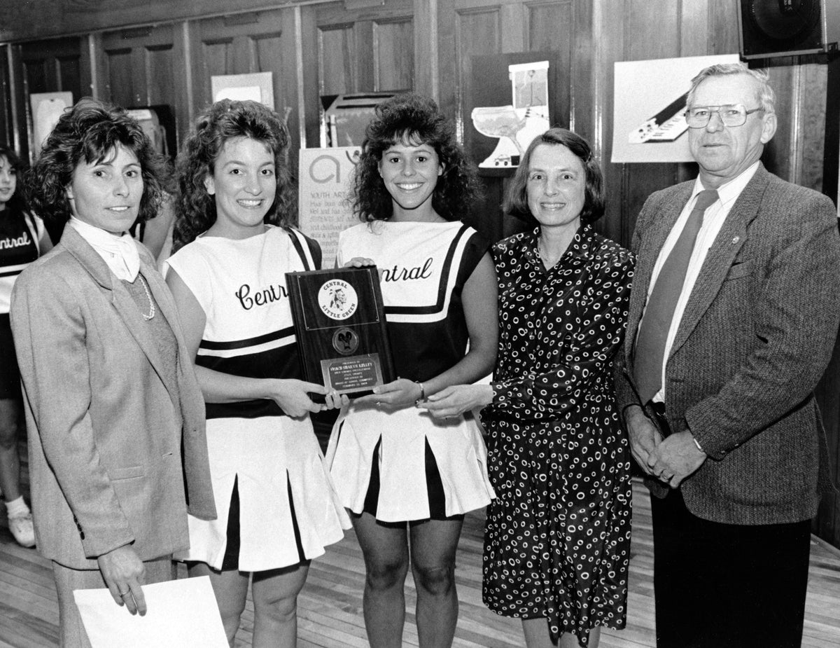 Members of Central High School cheerleading squad who won the state cheering title, being honored by Manchester's Board of School Committee in 1989. From left: Coach Sharyn Kelley, Co-Captain Monique Daigle, Co-Captain Heidi Sullivan, School Board Chairperson Carol Resch and Sports Committee Chairman Eugene Boisvert. Courtesy Arlene Sullivan