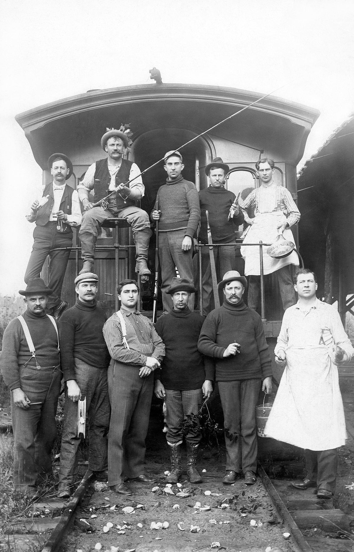 A group of fishermen, chefs, and hunters on a train, circa 1905. Front row, left: Henry Thuss, unidentified, unidentified, Matt Wright, Mike Griffin, John E. Adler. Back row: Ed Dumas, Henry Kreisch, unidentified, Frank Noll, unidentified. Courtesy North Wood County Historical Society / #U100.16-1