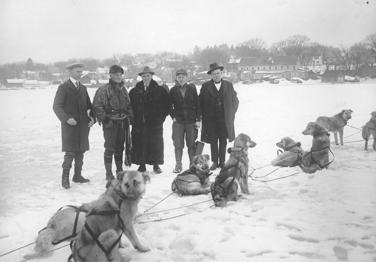 Arthur Treadwell Walden, second from left, with his Chinook dog sled team on the frozen lake, circa 1922. Walden, a New Hampshire resident, was in the process of popularizing the sport of dog sled racing in New England around this time. Also pictured, from left, are Claude Calvert, Charles W. Small, Charles S. Cowing, and Frederick L. Hawkins. Meredith Historical Society