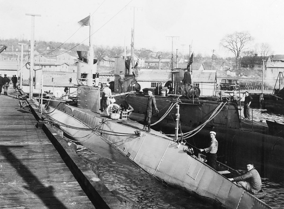 In port at the Subase, circa 1918. The submarine at left is either USS H-1 (SS-28) or USS H-2 (SS-29). That in the middle is USS G-1 (SS-19½). The submarine on the right is unidentified. U.S. Naval History and Heritage Command Photograph