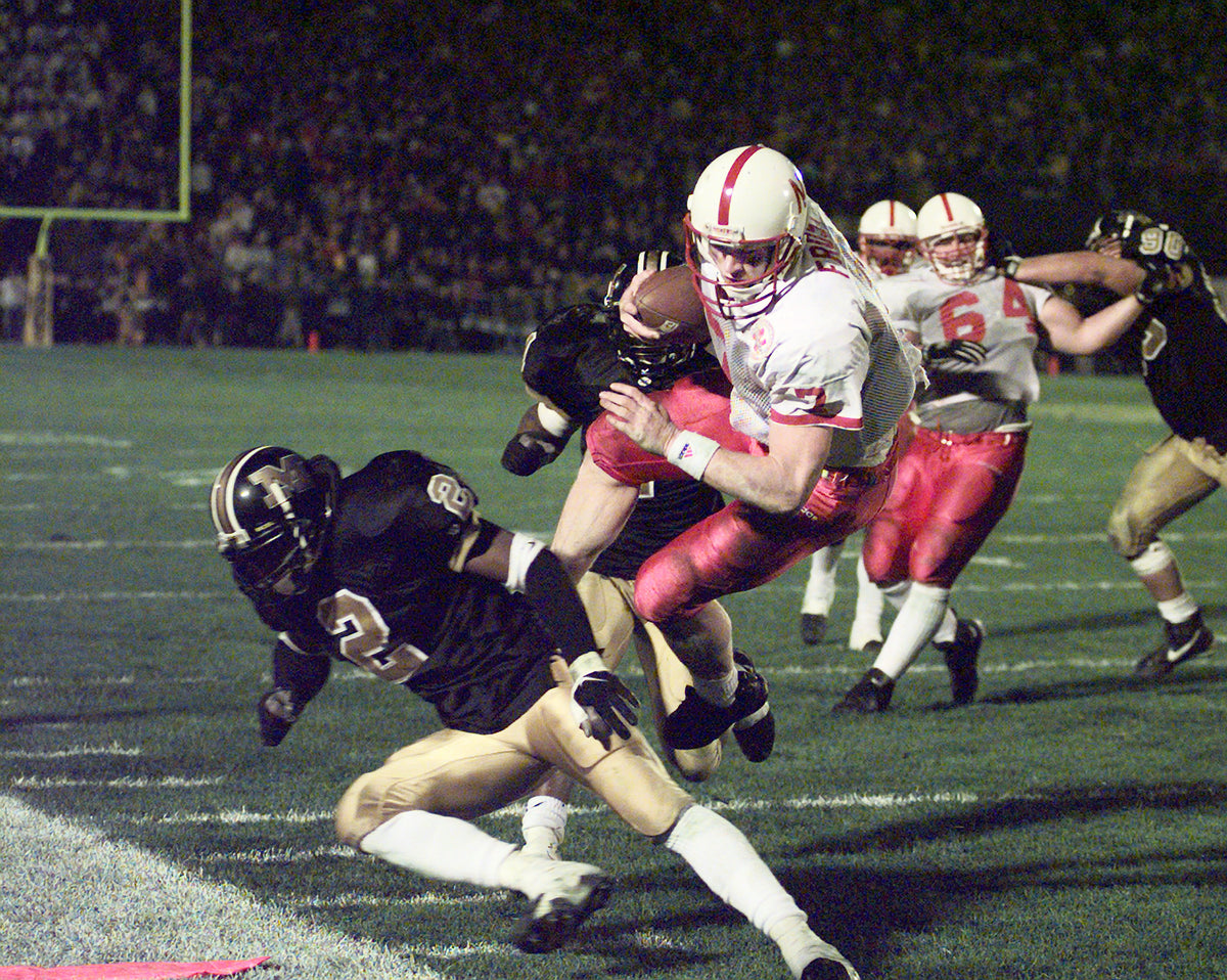 Nebraska quarterback Scott Frost leaps over Missouri safety Harold Piersey to score the winning touchdown in overtime at Faurot Field in Columbia. The Huskers rallied with touchdowns on the last play of regulation and in overtime for the 45-38 victory. Courtesy Lincoln Journal Star