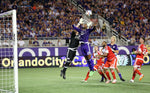 Orlando City’s Cyle Larin goes up for a header as New England keeper Bobby Shuttleworth grabs the ball during the Lions’ game against the New England Revolution. Jacob Langston / Orlando Sentinel
