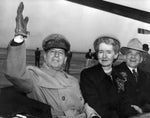 General Douglas MacArthur, gloved hand uplifted, returning the cheers of a curbside crowd from the airport to Veterans Hospital and back on his rapid tour through Portland, November 1951. Mayor Dorothy McCullough Lee and Governor Douglas McKay accompanied the general in the lead car of the parade, delayed almost four hours by fog which prevented landing of the planes. Courtesy Oregonian Archives