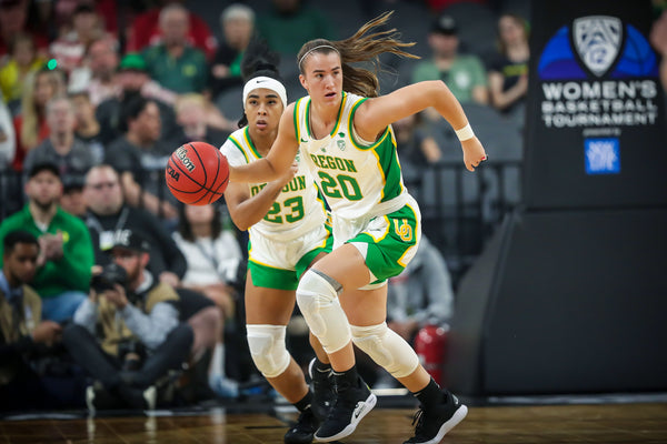 Oregon's Sabrina Ionescu dribbles and Minyon Moore trails during the first half as the No. 1 seed Oregon Ducks face the No. 3 seed Stanford Cardinal in the championship game of the Pac-12 women's basketball tournament on March 8, 2020, at Mandalay Bay Events Center in Las Vegas. Courtesy Serena Morones, The Oregonian/OregonLive