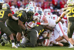 Multiple Oregon defenders are in the scrum as the Ducks battle Wisconsin. The Ducks forced four Badgers turnovers en route to their 28-27 victory. Courtesy The Oregonian / Sean Meagher