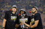 Oregon quarterback Justin Herbert, nose tackle Jordon Scott and linebacker Troy Dye pose for a photo after the No. 6 Ducks defeat the No. 8 Wisconsin Badgers 28-27 in the 106th Rose Bowl college football game in Pasadena, California, on Jan. 1, 2020. Courtesy The Oregonian / Sean Meagher