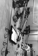 Operating remote control arms in test cells of addition to Nuclear Reactor, circa 1973. Penn State University Archives, Paterno Library