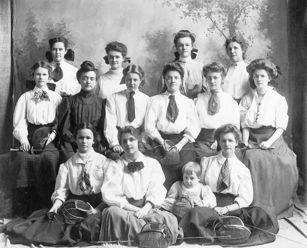 Penn State Women’s fencing team, circa 1906. Left to right, top row: Carolyn Buckhart, Alverra Martin, Millicent Pond, Bess Brown. Middle row: Clara Pond, Florence Benedict, Anne Keichline, Laura Harrison, Nettie Cook, Mary Louise Hackel. Bottom row: Eleanor Walsh, Mary Kathryn Jackman, Gertrude Walsh, child is the daughter of Mr. Higby, teacher of mathematics. Penn State University Archives, Paterno Library