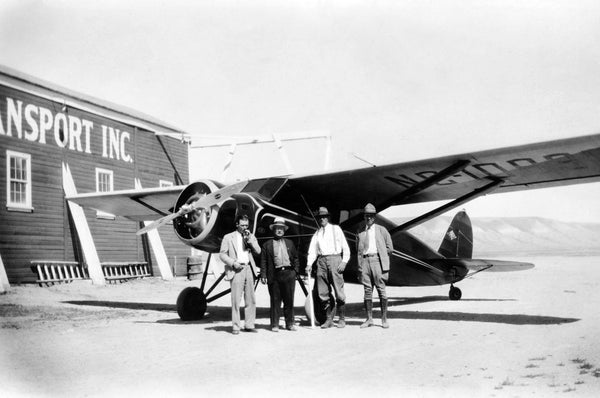 Plane at Rock Springs Airport, circa 1930. Second from left is Mr. Bowman, District Engineer at Casper. Third from left is T. M. Morton, Locating Engineer. Wyoming State Archives