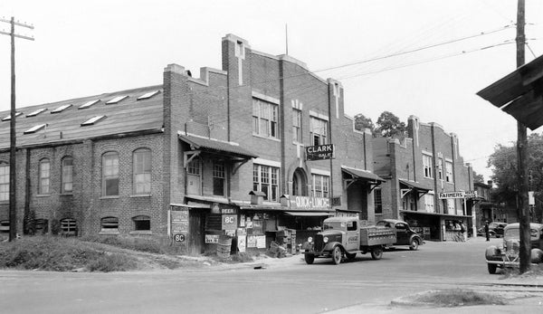 A Coca-Cola truck and other vehicles parked on the street by a Farmers Warehouse in Edgecombe County, circa 1939. Courtesy Edgecombe County Memorial Library / #PH 409