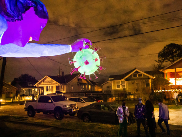 A satiric superhero dubbed ‘Super Spreader’ carries the COVID-19 virus up, up and away from a house float presented during the Krewe du Vieux’s Jan. 30, 2021, ‘stationary parade.’ The group, known for its bawdiness and biting political satire, was one of the first parading organizations to envision scattered exhibits as an alternative to conventional parading. Sophia Germer / The Times-Picayune | The Advocate