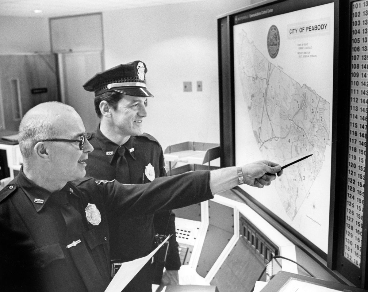Sgt. John Havenook and Ptl. Harry Birmingham reviewing the electronic map that shows location of Peabody Police Department patrol cars, May 3, 1980. Courtesy The Salem News