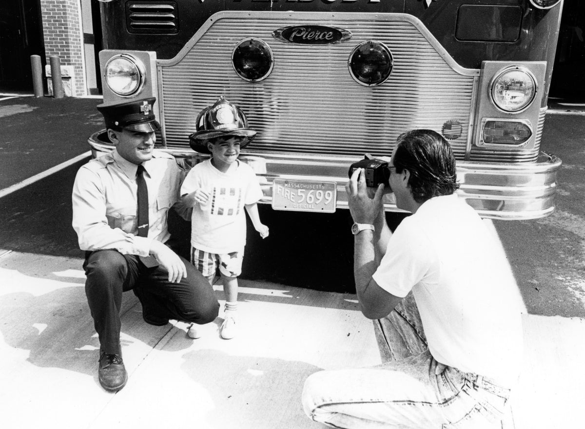 George Zolotas (age 3) with Peabody firefighter Joe de Franco at the open house for the newly restored fire house, circa 1989. Courtesy The Salem News