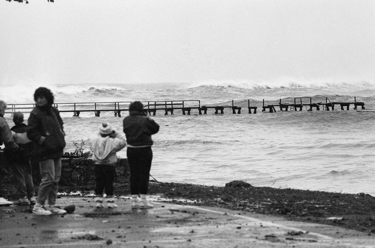 Storm watchers look on as waves batter the Magnolia Pier. The brunt of the storm had yet to arrive. Cristin Bradley/Gloucester Daily Times