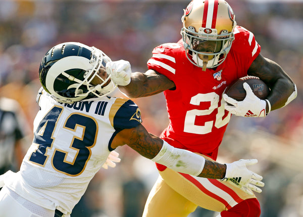 San Francisco 49ers' Tevin Coleman stiff arms Los Angeles Rams' John Johnson III during a 2nd-quarter touchdown run during a game at Los Angeles Coliseum in Los Angeles on Oct. 13, 2019. Scott Strazzante/The Chronicle