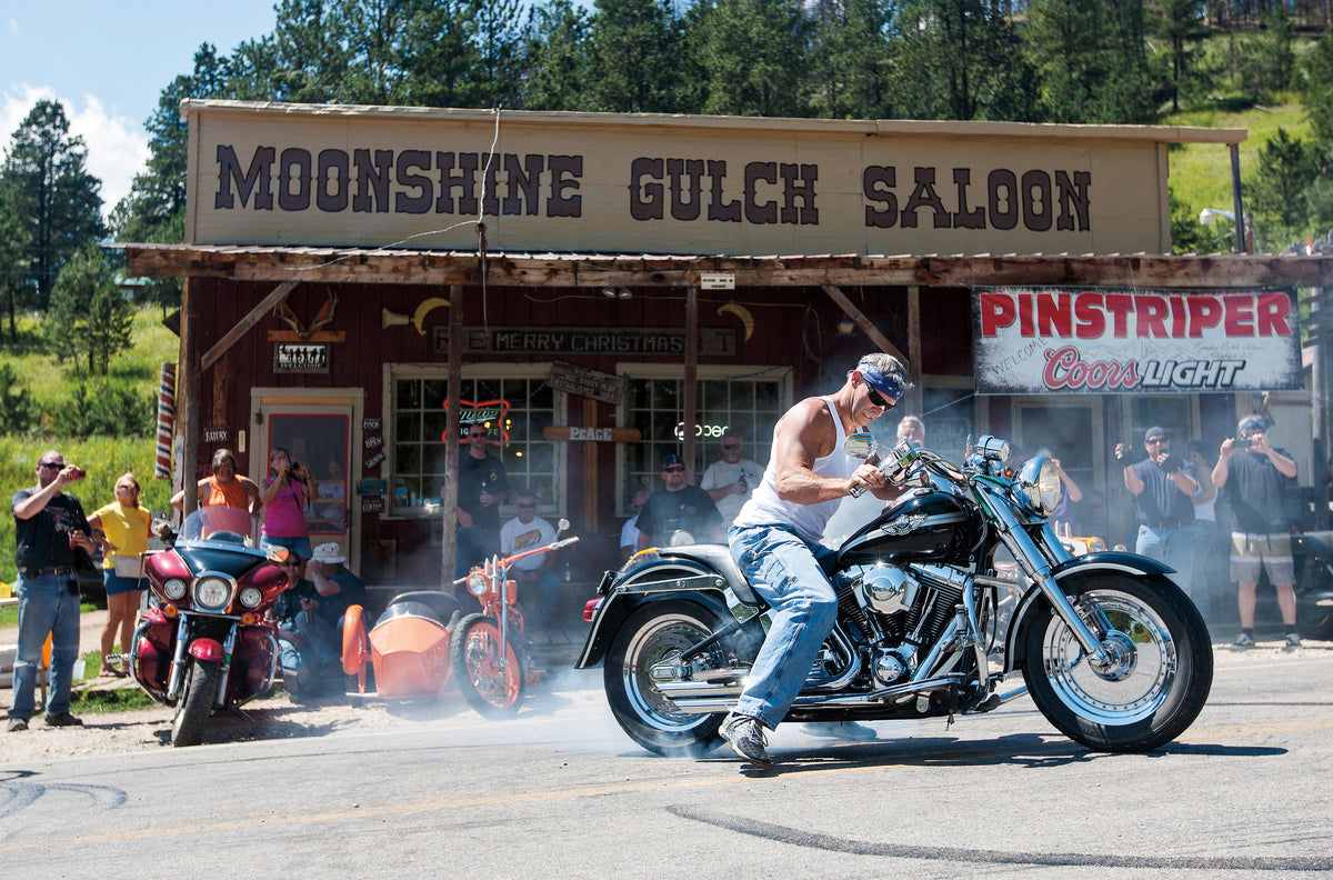 Russ Kerstetter of Kansas City, Mo. uses his 2003 Harley-Davidson Fat Boy to perform a burnout in front of the Moonshine Gulch Saloon in Rochford, S.D. in 2014.