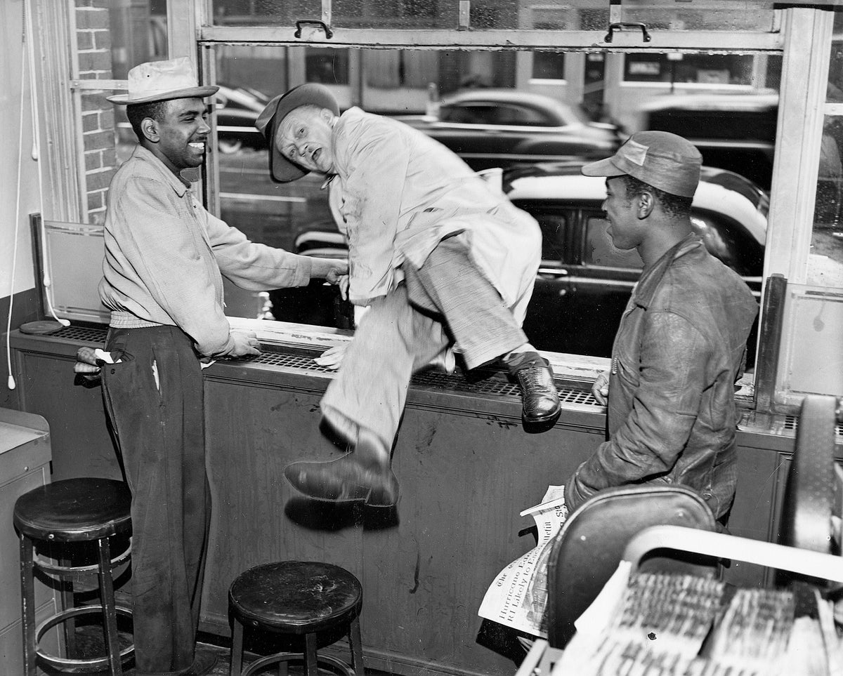 Maurice H. Caldwell of Waterman Street clambering through a window of the hurricane-barricaded Providence Journal to place an ad, September 1954. Courtesy The Providence Journal