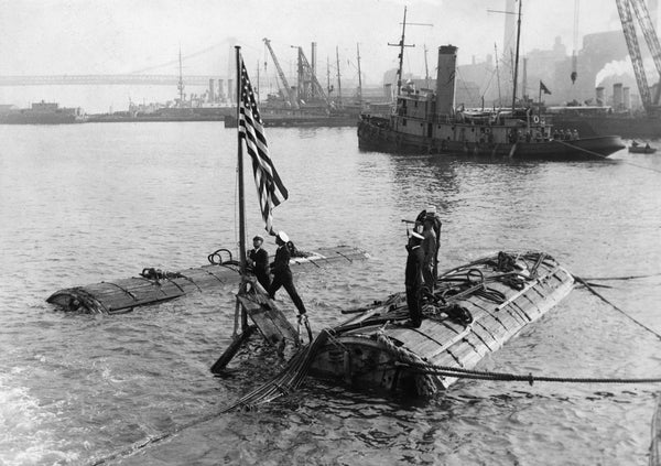 Taps is sounded at the Brooklyn Navy Yard in New York as the flag of the USS S-51 is lowered while the recovered submarine is supported by pontoons on July 8, 1926. US Navy Submarine Force Museum