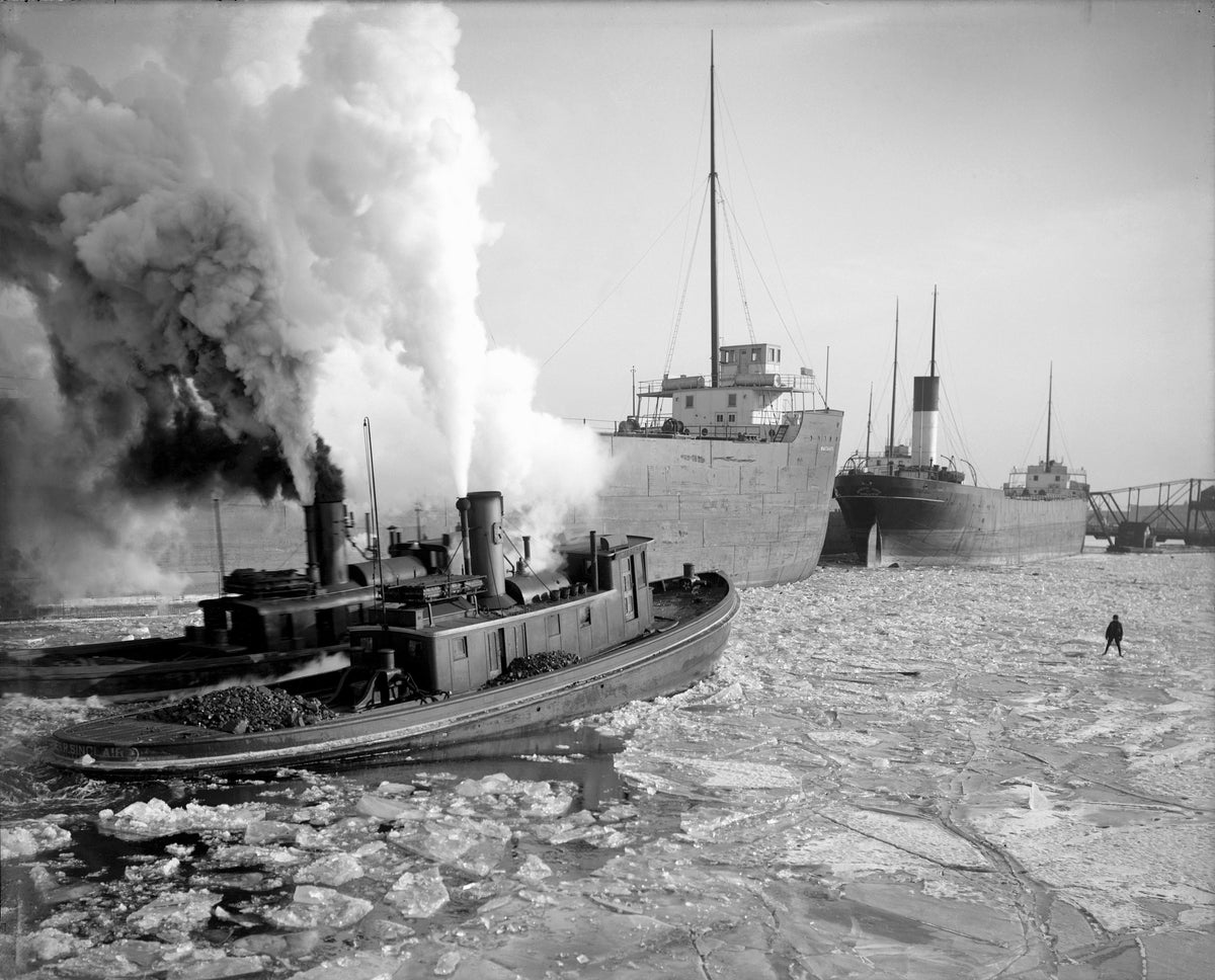 Tugboats Sinclair and Record breaking ice for the bulk freighters Mataafa and Queen City in the Duluth-Superior Harbor on February 5, 1908. The Arrowhead Bridge between Superior and Duluth is in the background. Courtesy Lake Superior Maritime Collection, University of Wisconsin-Superior