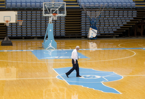 UNC coach Roy Williams walks across the court in the Smith Center prior to hosting his 27th annual Special Olympic basketball clinic on February 8, 2015, in Chapel Hill, N.C. Three hours later Williams would address the media on the death of his mentor Dean Smith. Courtesy Robert Willett / The News & Observer