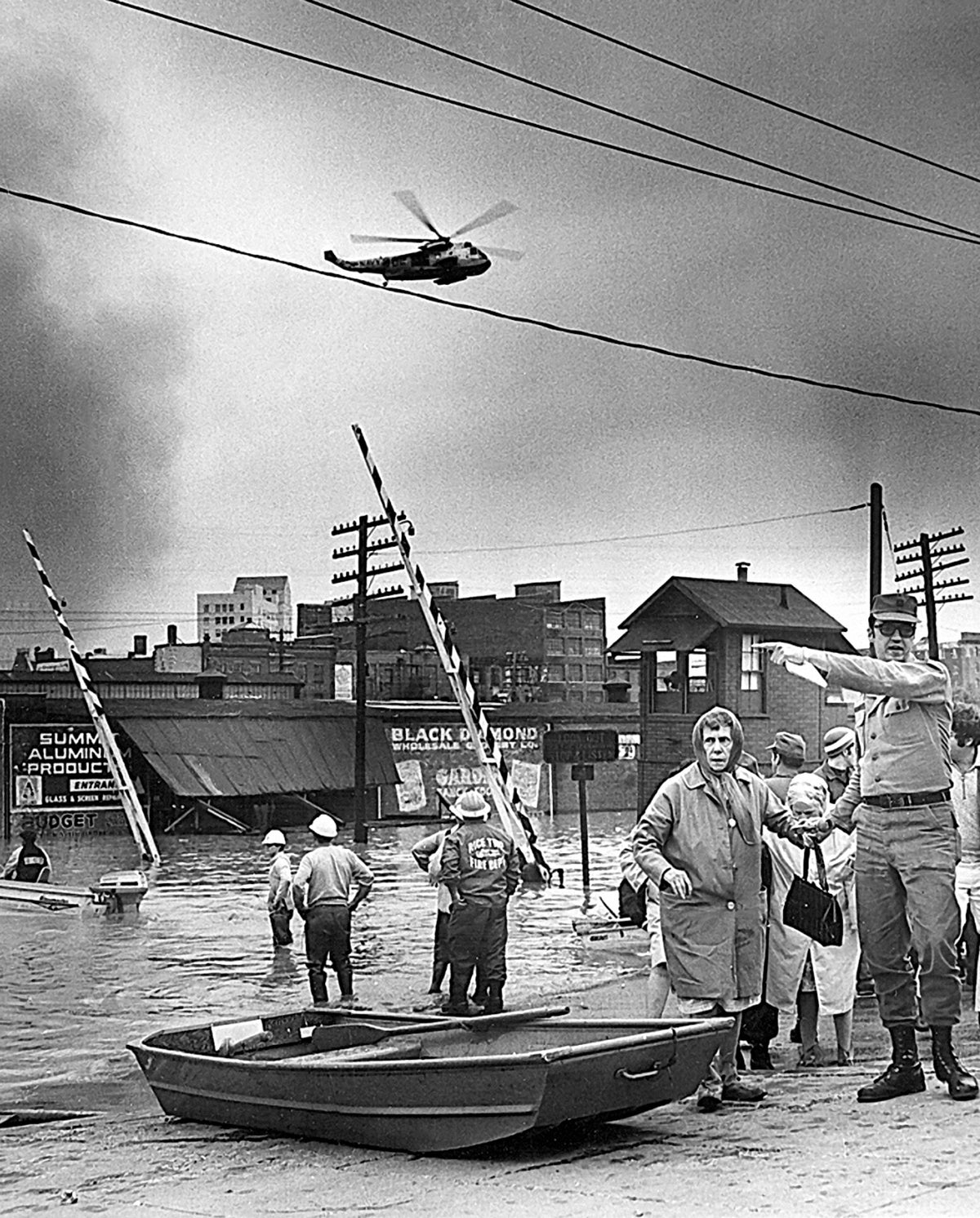A helicopter hovers overhead as a rescue worker directs evacuees to a shelter center in the Northampton Street area. Times-Tribune Archives