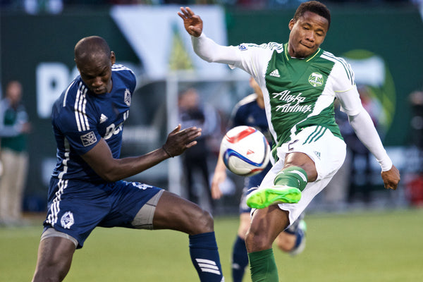The Portland Timbers Alvas Powell makes a shot on goal against Vancouver Whitecaps's Pa Modou Kah, at Providence Park, February 22, 2015. Thomas Boyd/The Oregonian