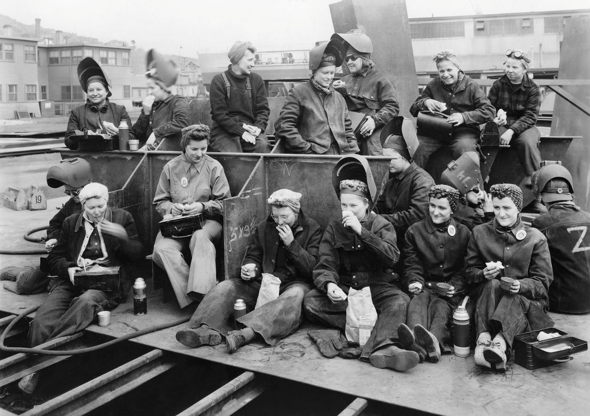 Welders eating lunch in front of the Outfitters Shop at Zenith Dredge Company, Duluth, May 28, 1943. At this time Zenith Dredge Company was the only shipyard at the heads of the lakes which employed women in its yard. Courtesy Douglas County Historical Society, Superior, Wisconsin