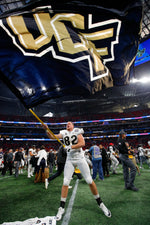 Long snapper Rory Coleman proudly waves the UCF flag on the field at Atlanta’s Mercedes-Benz Stadium after the Knights upset Auburn to cap a perfect season.  Todd Kirkland / Icon Sportswire