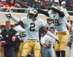 Michigan Charles Woodson (2) celebrates his second interception of the day, Oct 25, in East Lansing, MI. MSU quarterbacks through for six interceptions for the day during UM 23-7 win over MSU. UM teammate (29) Ray Marcus is behind on the right. Julian H. Gonzalez / Detroit Free Press