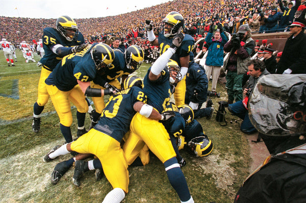Michigan cornerback Charles Woodson is somewhere under a pile of celebrating teammates after his 2nd quarter punt return for a touchdown against Ohio State University on Nov. 22, at Michigan Stadium in Ann Arbor, MI. Michigan went on to beat  OSU 20-14 and earn a trip to the Rose Bowl and the Big Ten Championship. David P. Gilkey / Detroit Free Press