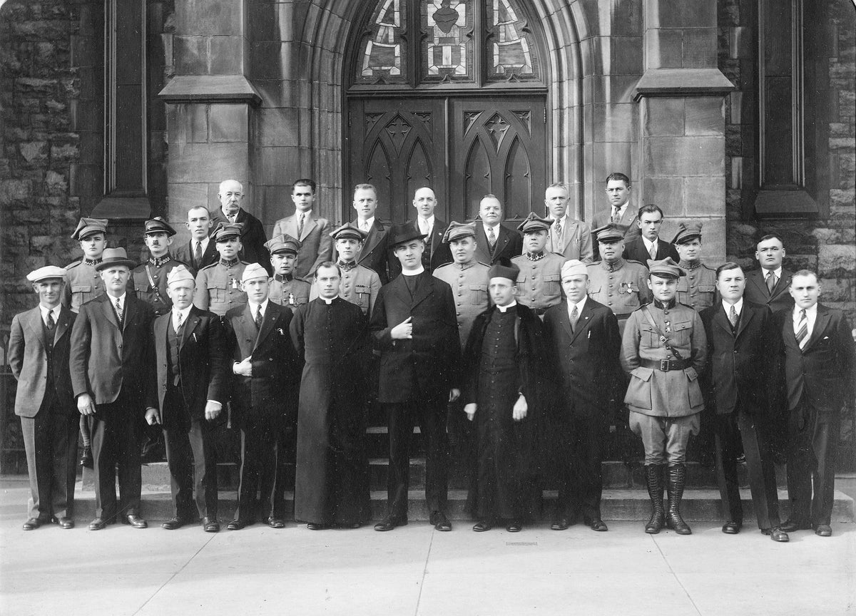 Priests and soldiers dressed in Polish military uniforms in front of Trinity Church on Lincoln Avenue, Utica, circa 1920. Several are wearing hats worn by Officers of the Polish Army in France.