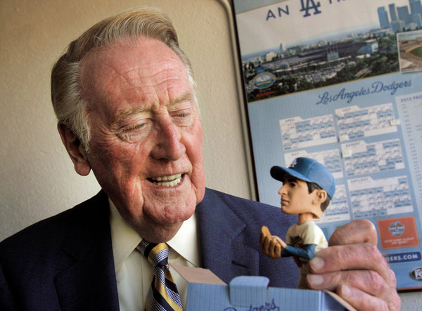 Vin Scully looks at his Sandy Koufax bobblehead on the 47th anniversary of Koufax’s perfect game. This memory came on Aug. 7, 2012. Lawrence K. Ho / Los Angeles Times