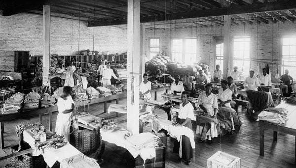 Interior view of the clothes repair, pressing, and packing room in a warehouse building at the United States Laundry, circa 1916. The laundry cleaned, pressed, and repaired the clothes for military personnel at various military cantonments. Courtesy State Archives of North Carolina / #WWI 2.B11.F27.3