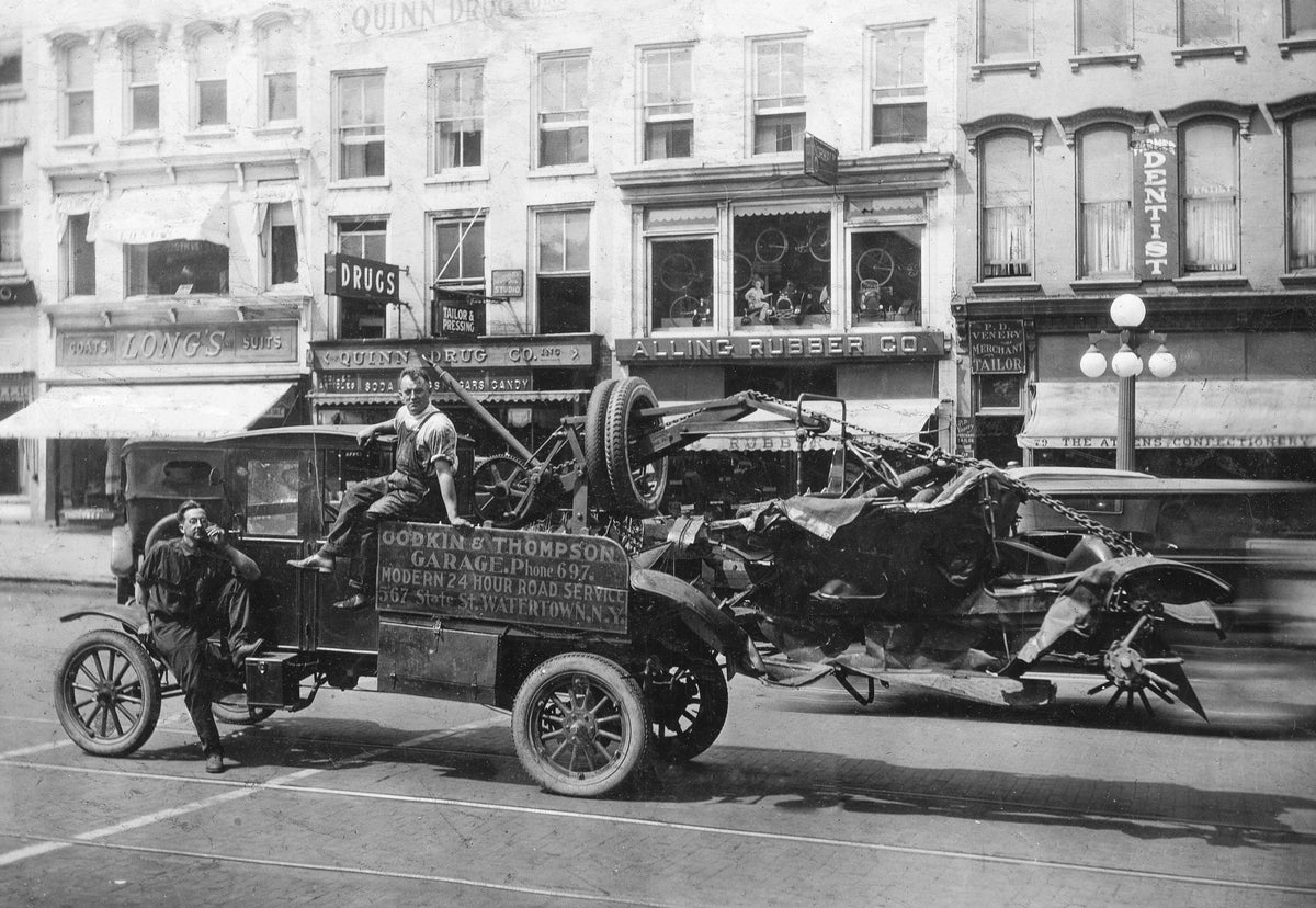 Godkin & Thompson Garage employees towing a damaged vehicle, circa 1915. Courtesy Jefferson County Historical Society / #2003.80.09