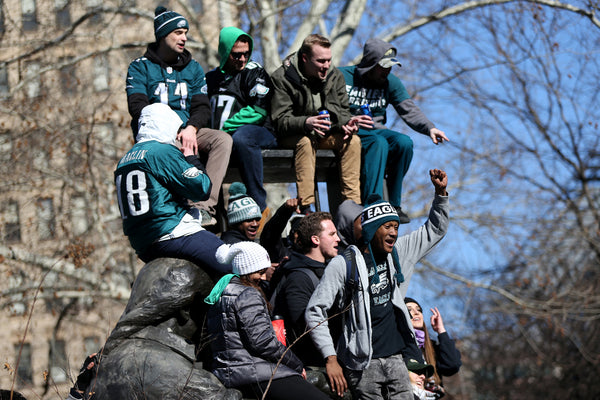 A statue near City Hall becomes a seat for fans as the Eagles pass by. Courtesy Tim Tai / Staff Photographer