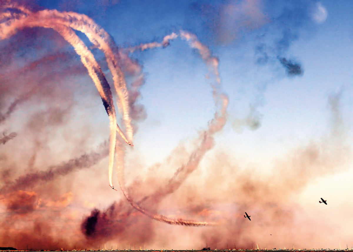 A photo shot during the Air and Water Show in 2011. It was hot and humid that afternoon, which made the exhaust from the planes linger. I warmified the photo which resulted in making the smoky scene look like a WWII dogfight. Mike Umbreit