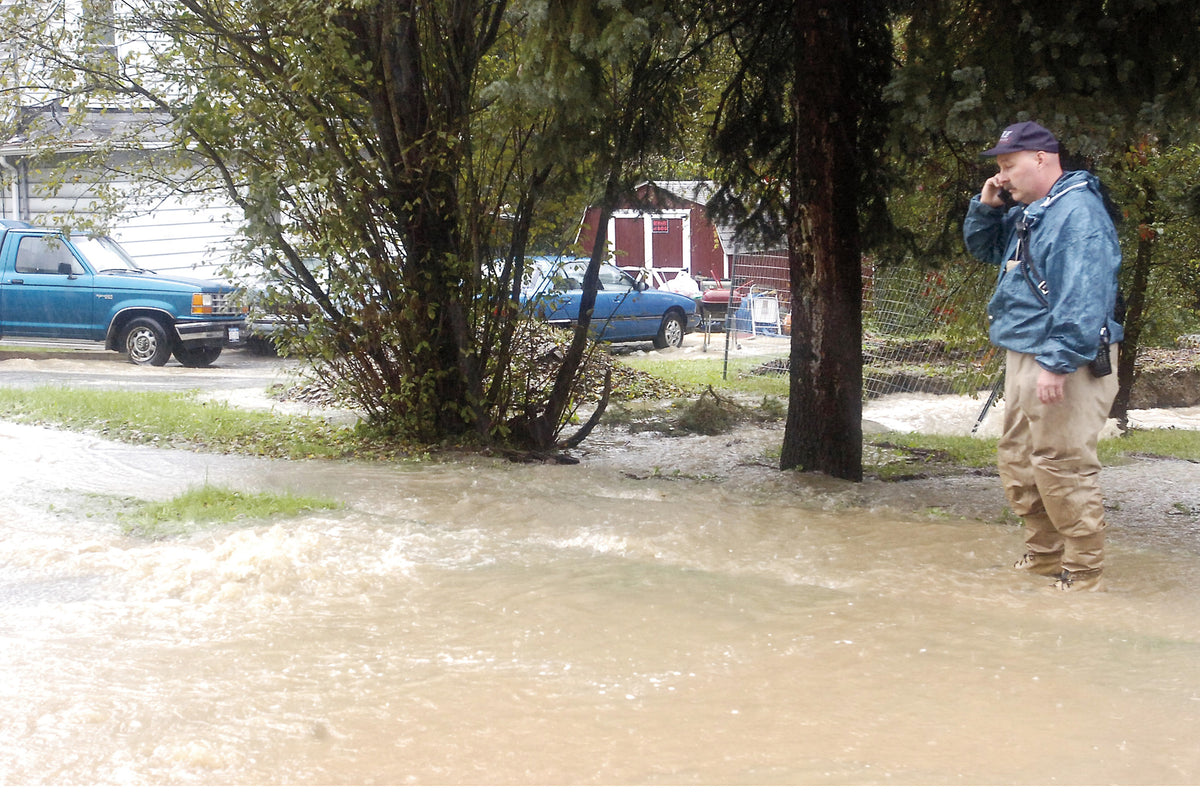 WILLIAM MOYER / Staff Photo Johnson City Fire Marshal Dave Nugent calls for the village's public works department to barricade Leigh Street at Old Deyo Hill Road, off Stella Ireland Road, where runoff rushed downhill and across the street Wednesday afternoon