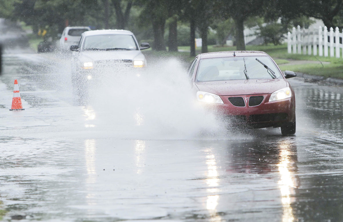 Motorists drive through standing water on College Avenue in Elmira near Woodlawn Avenue on Wednesday morning. JEFF RICHARDS / STAFF PHOTO